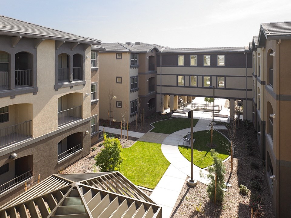 a view of the courtyard of an apartment building with a bridge