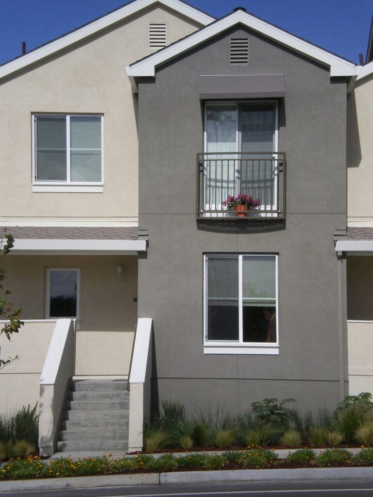 the front of a house with a balcony and steps