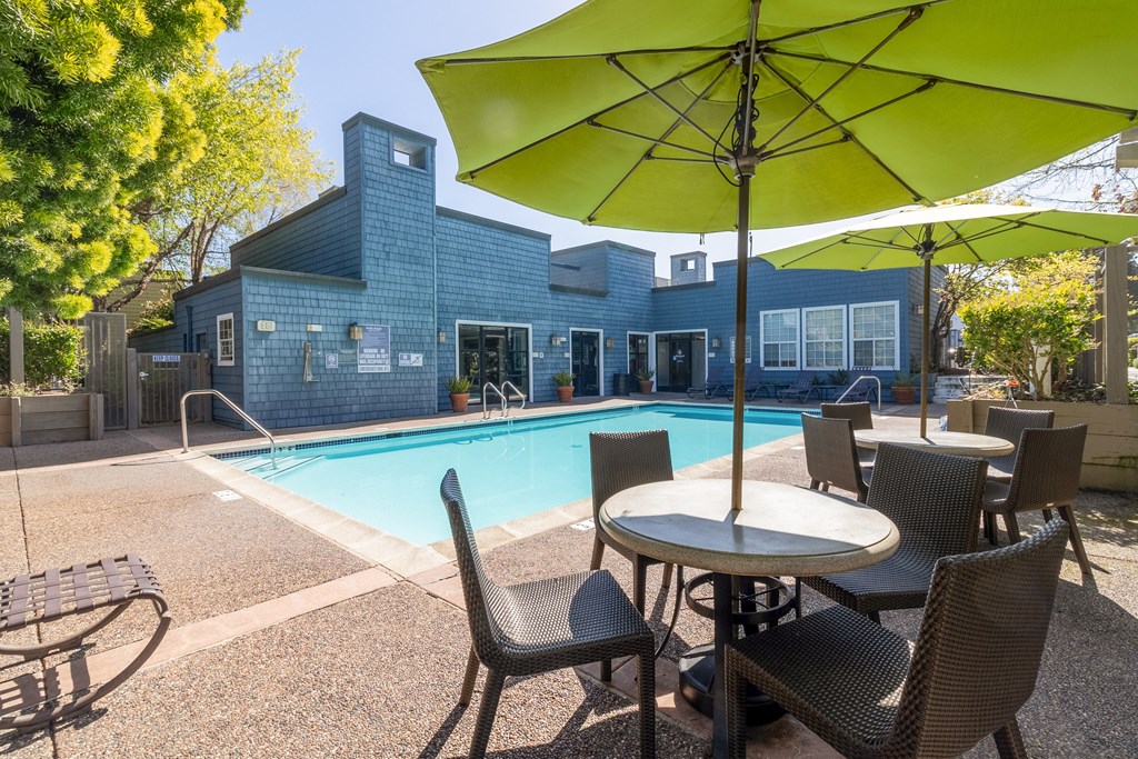 our apartments have a swimming pool with tables and chairs