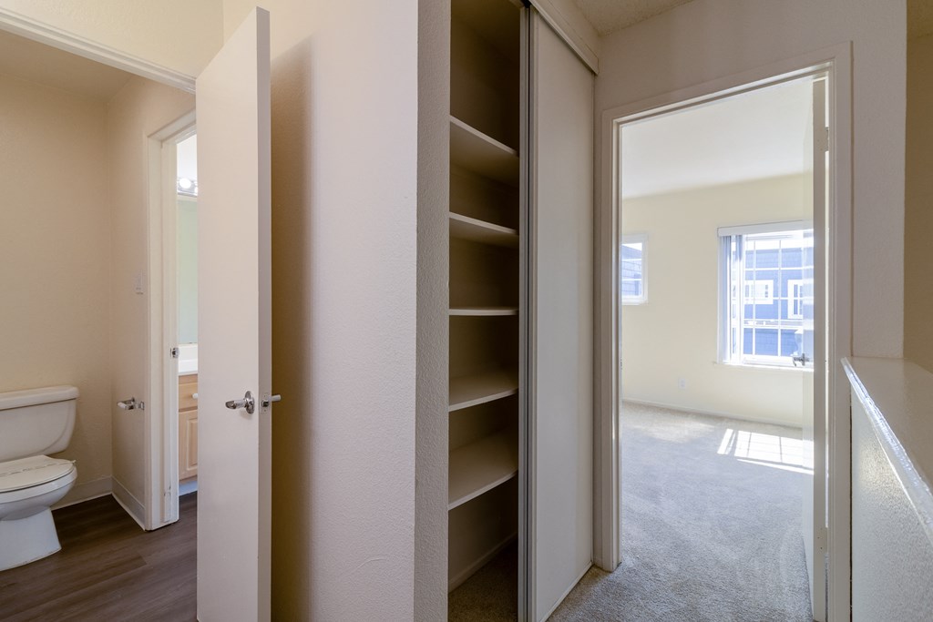 an empty bathroom with a closet and a toilet in it