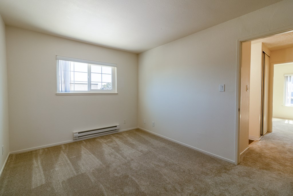 an empty room with an open door and a window
