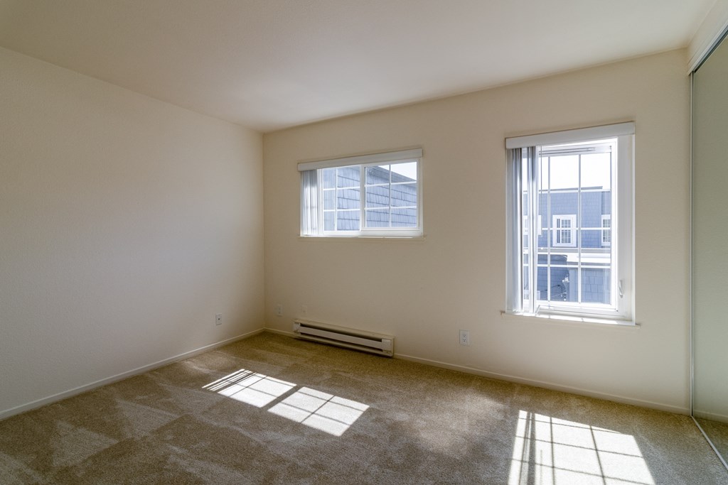the living room of an empty house with two windows