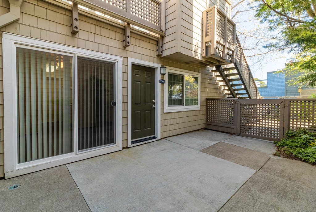 the front door of a home with a patio and a balcony