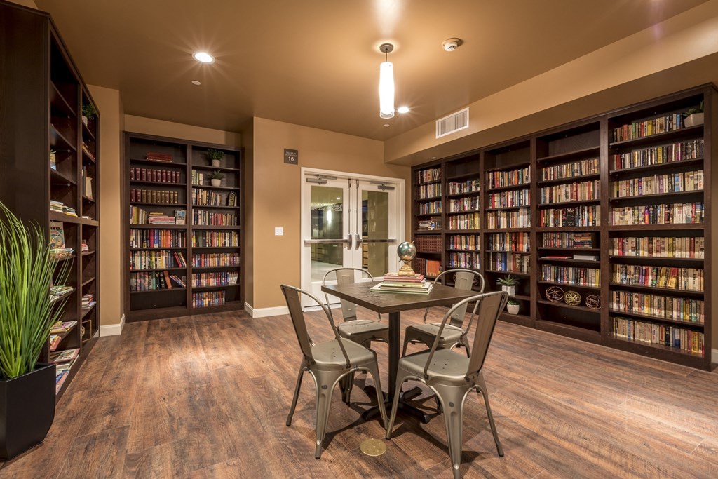 a library with a table and chairs and bookshelves