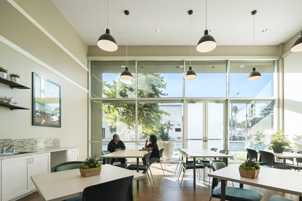 a dining room with tables and chairs and large windows