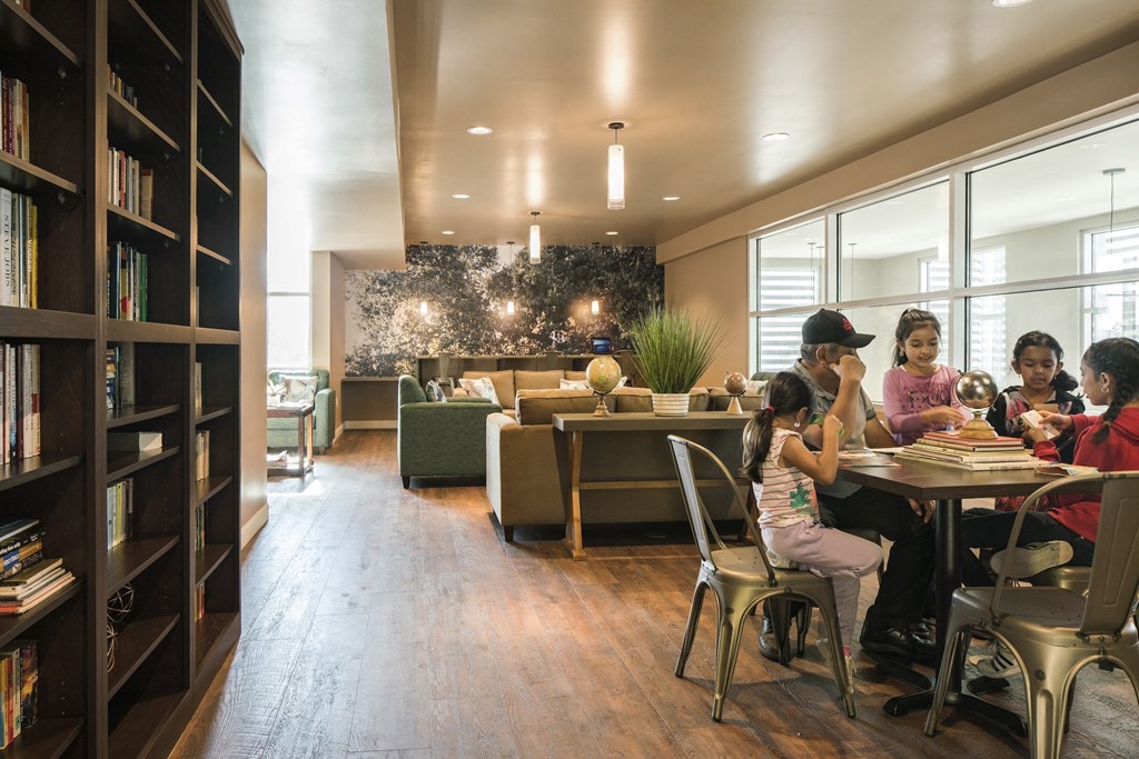 a group of people sitting at a table in a library