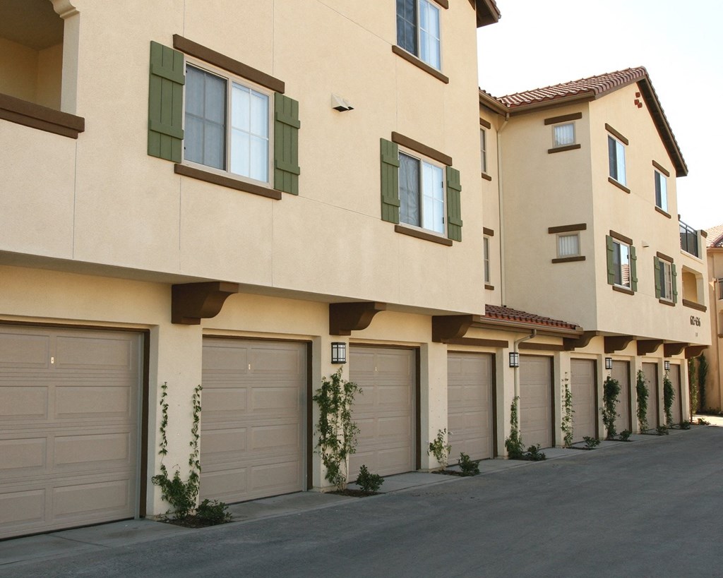 a view of a building with trees and garage doors
