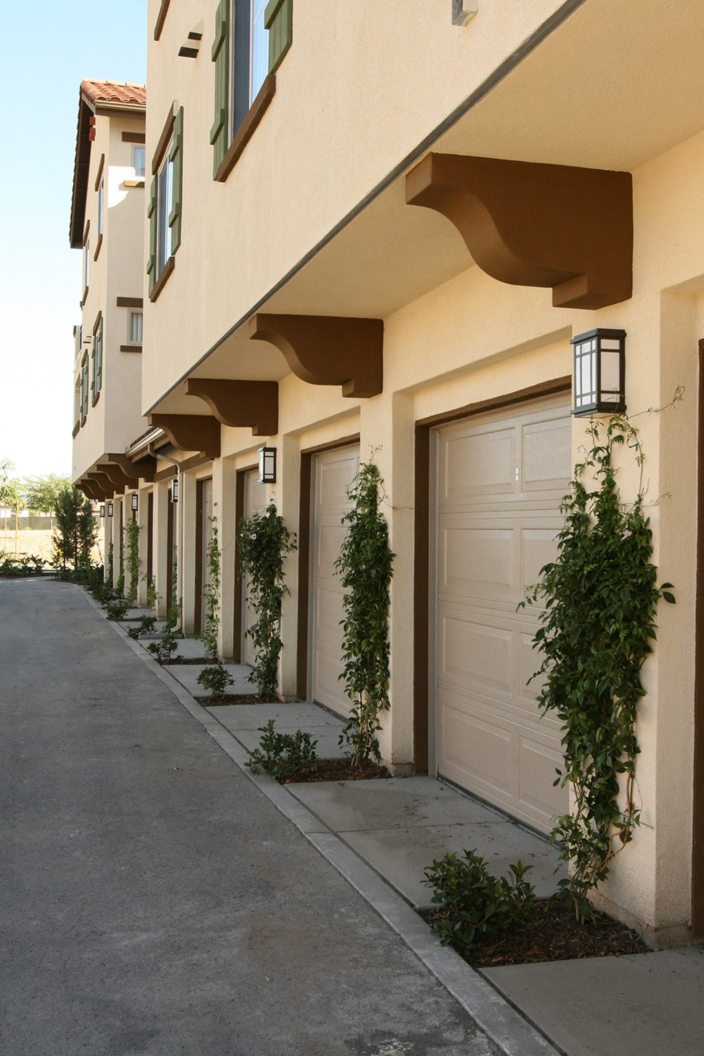 a row of apartments with white doors and plants