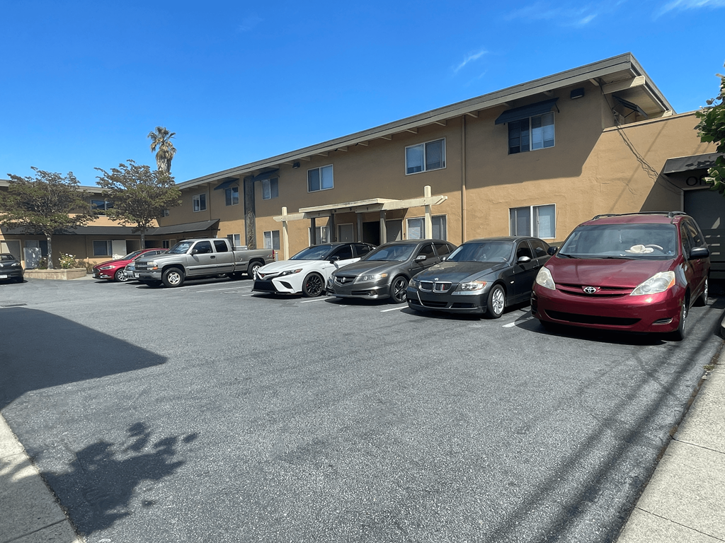 a parking lot filled with cars in front of a building