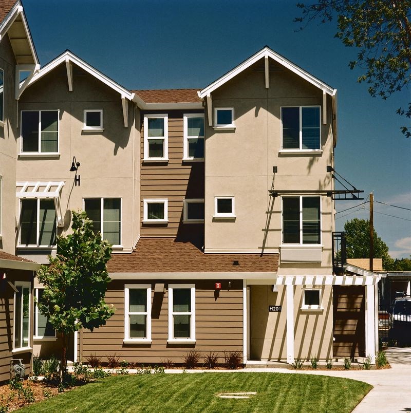 an apartment building with tan and brown siding