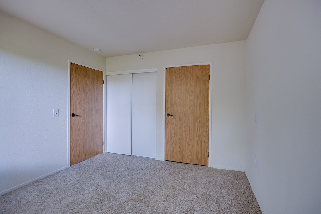 a bedroom with a carpeted floor and two doors