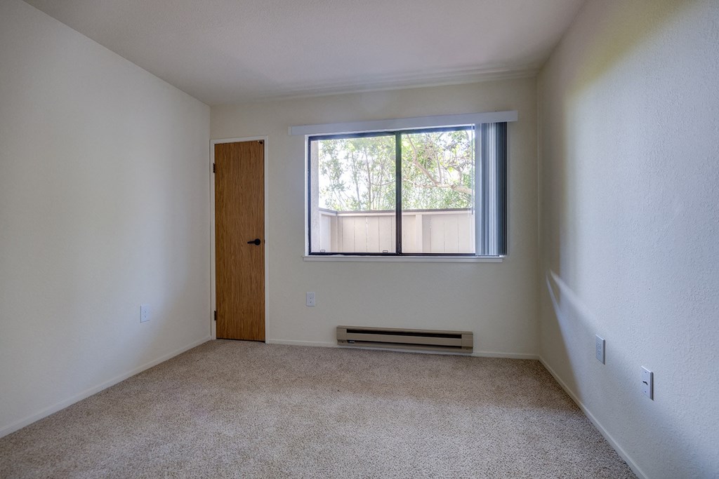 an empty room with a window and a door