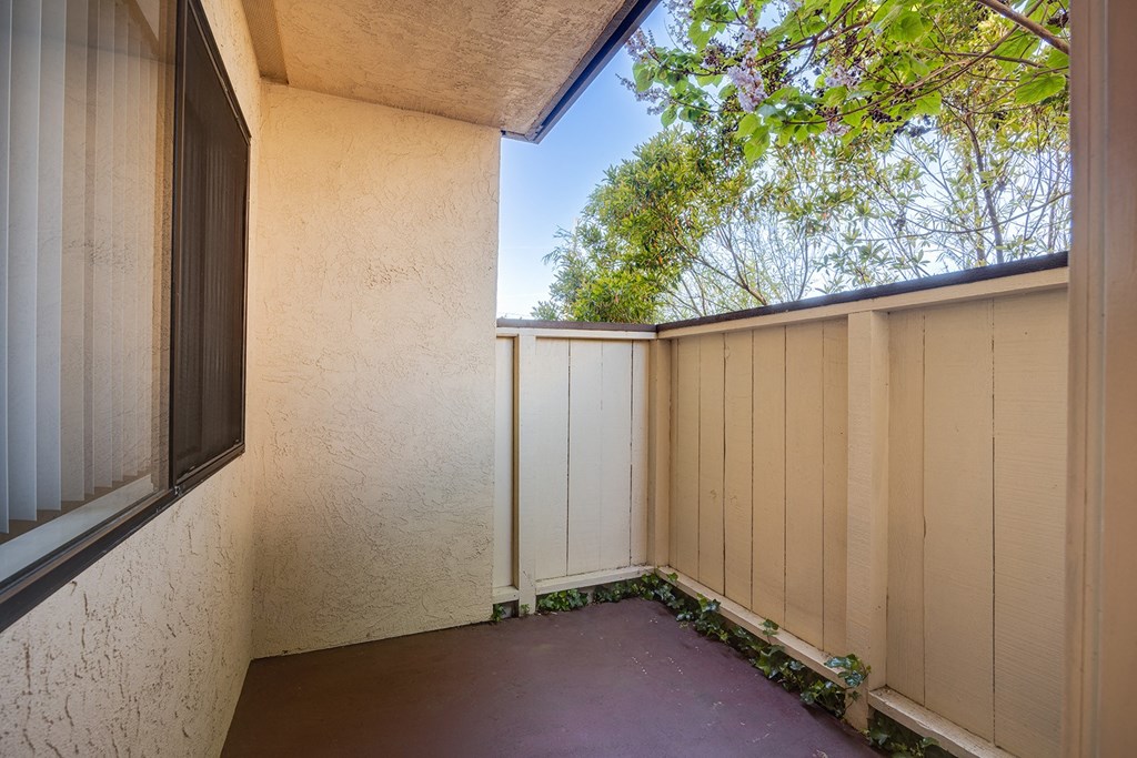 a balcony with a white fence and a window