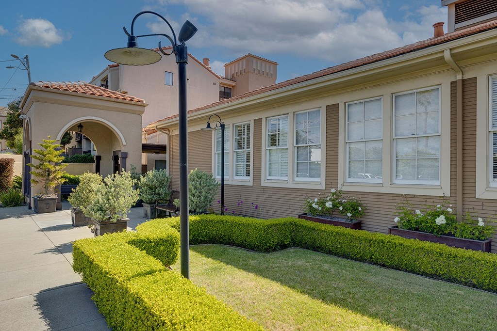 a house with a lawn and hedges in front of it
