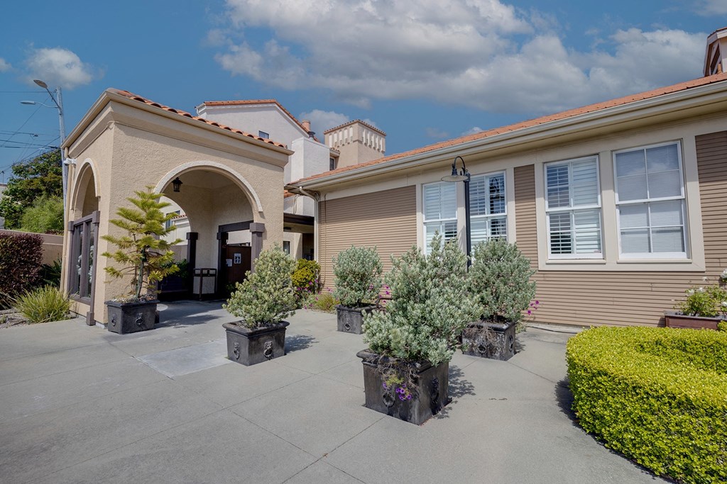 a house with a driveway and potted plants in front of it