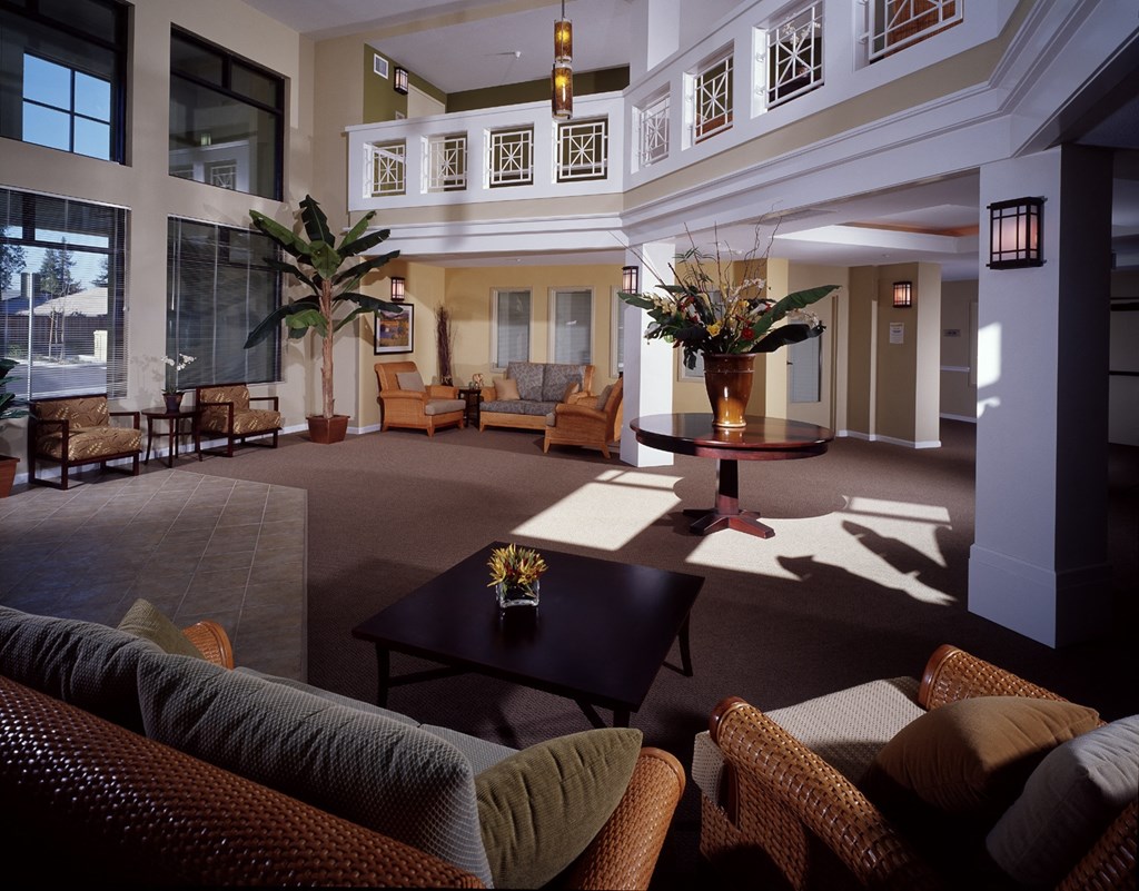 a lobby of a hotel with couches and a table