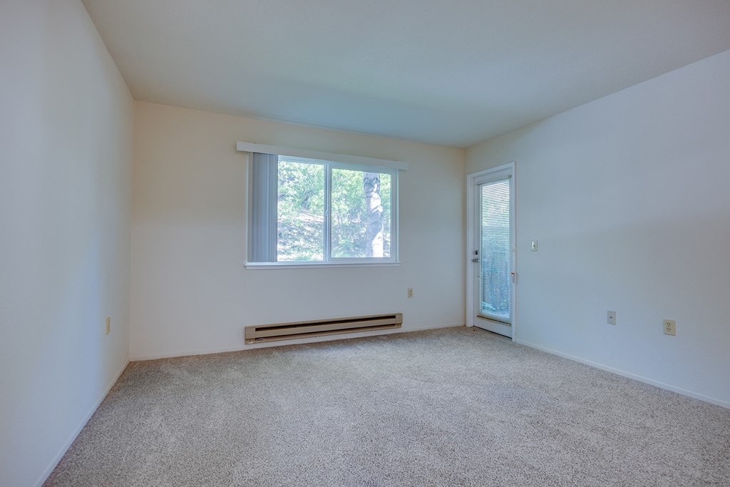 an empty room with carpet and a window