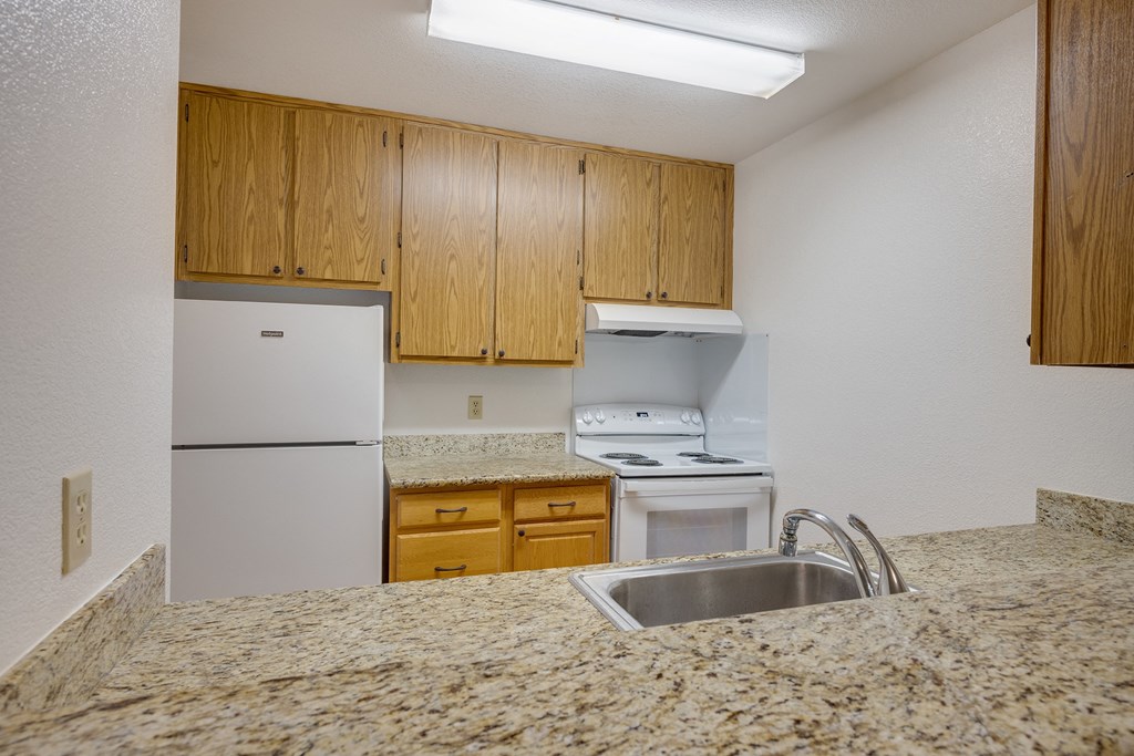 an empty kitchen with a sink and a refrigerator