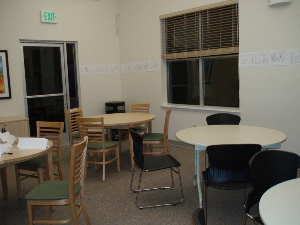 a seating area with tables and chairs in a room