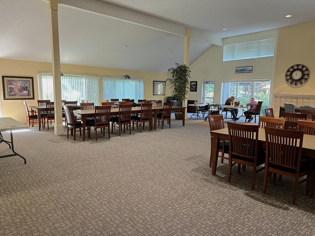 a dining room with tables and chairs in a room with windows