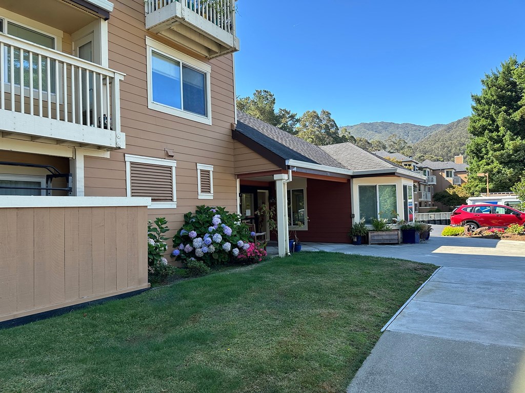 a house with a driveway and lawn in front of it