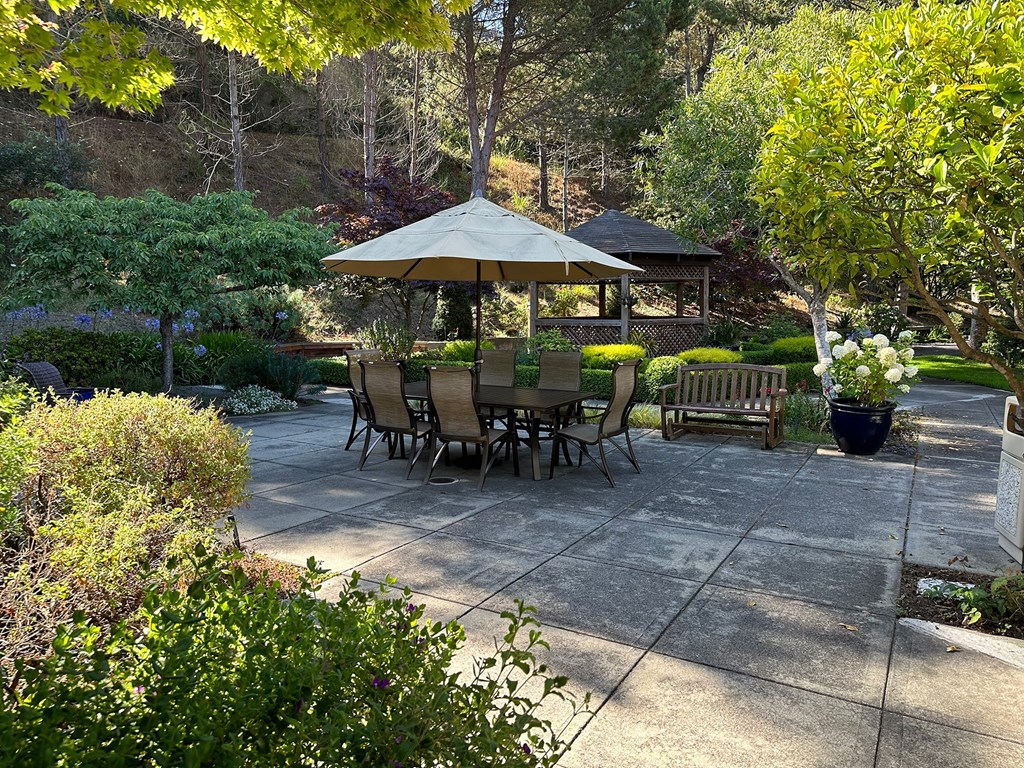 a patio with a table and umbrella and benches