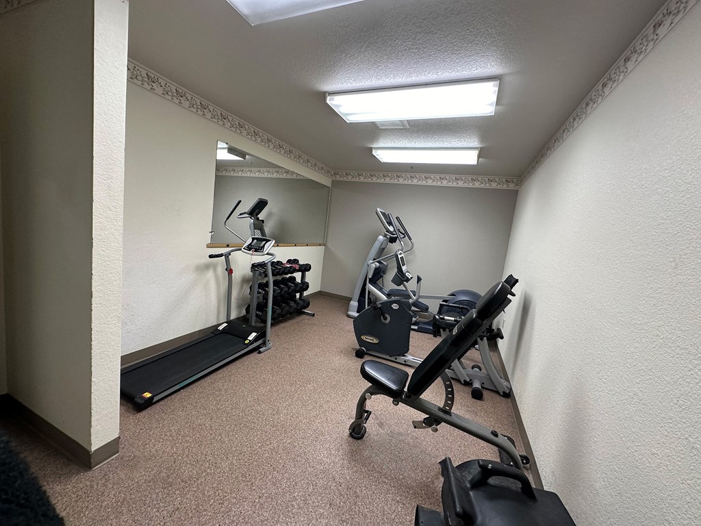 a gym with exercise equipment in the corner of a room