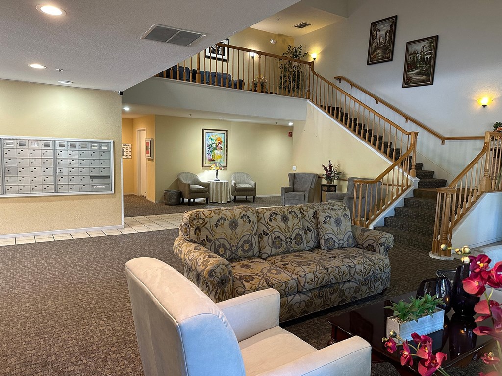 a lobby with a couch and chairs and a staircase