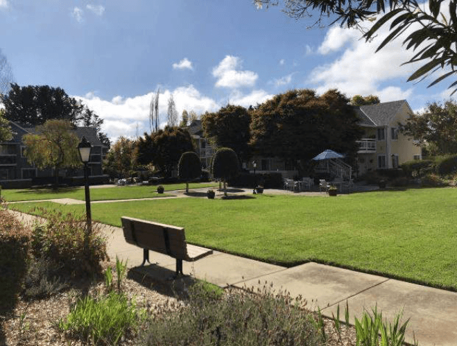 a park bench sitting in front of a grass field
