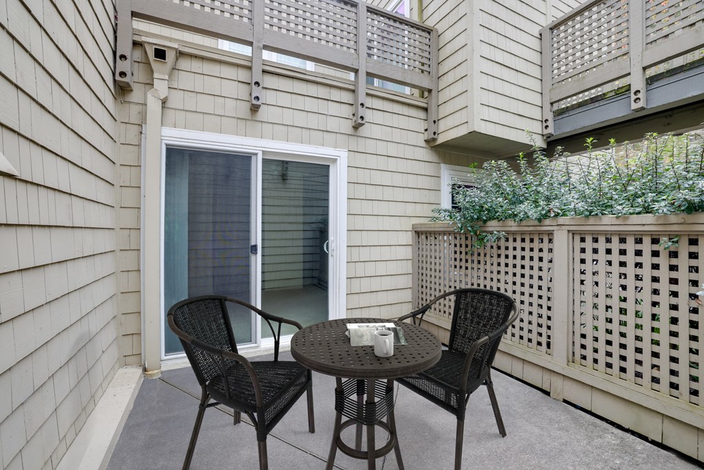 a patio with a table and chairs and a sliding glass door