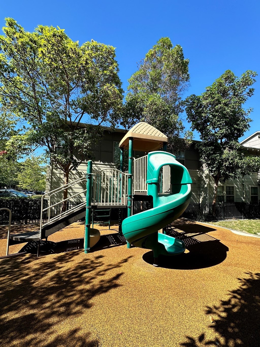 a playground with a green slide in a park