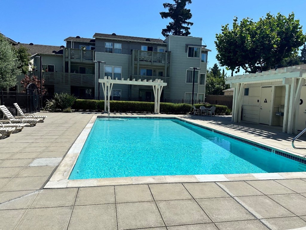 a swimming pool with an apartment building in the background