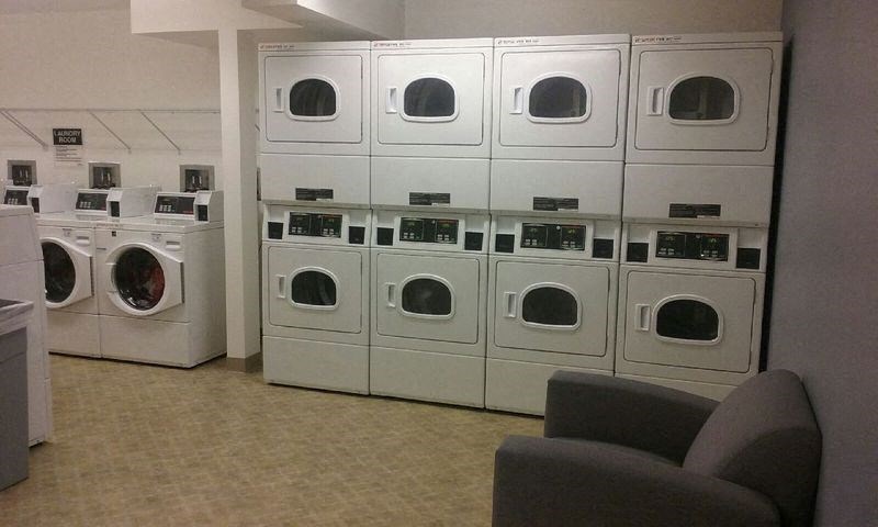 a row of washers and dryers in a laundry room