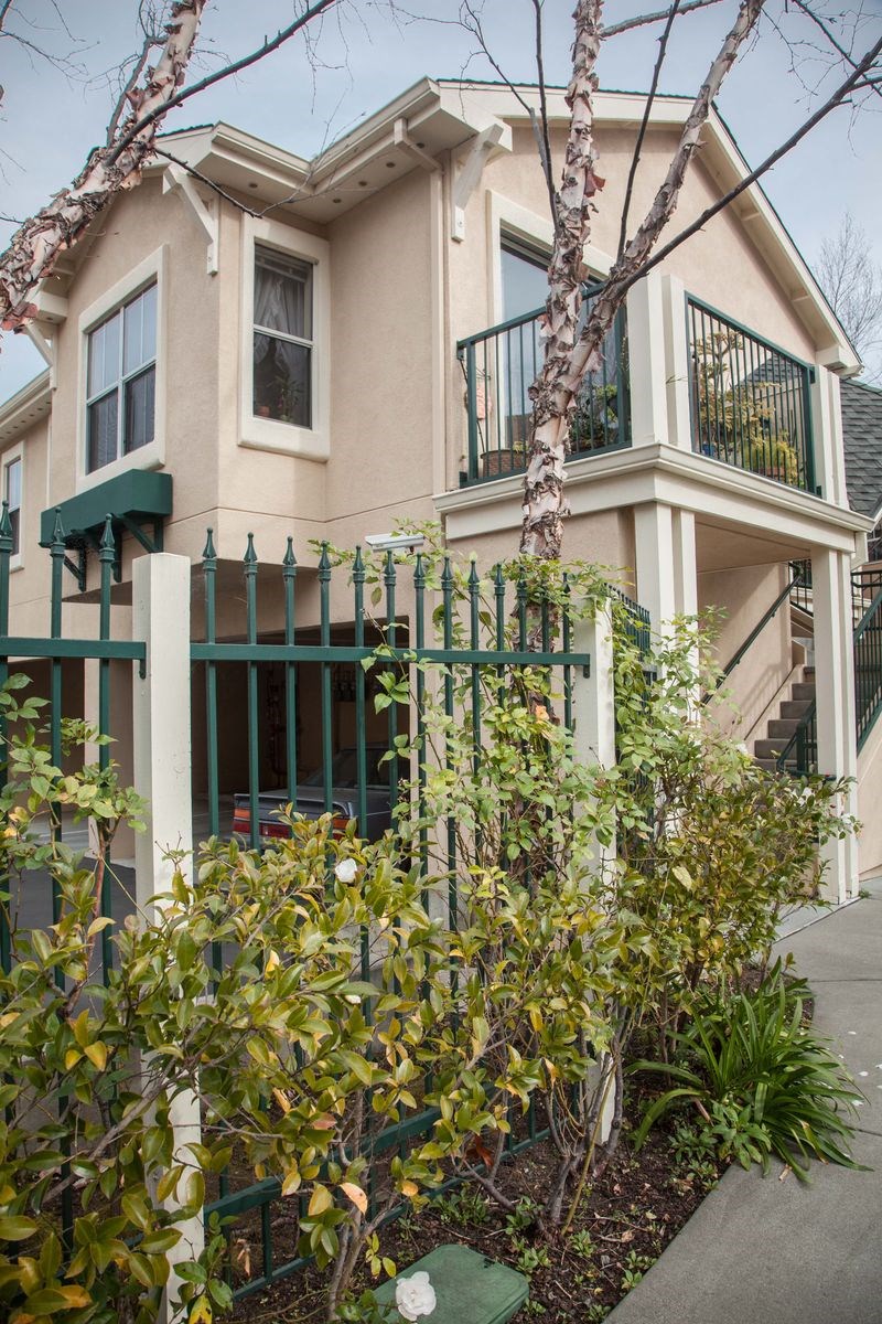 a house with a fence and plants in front of it