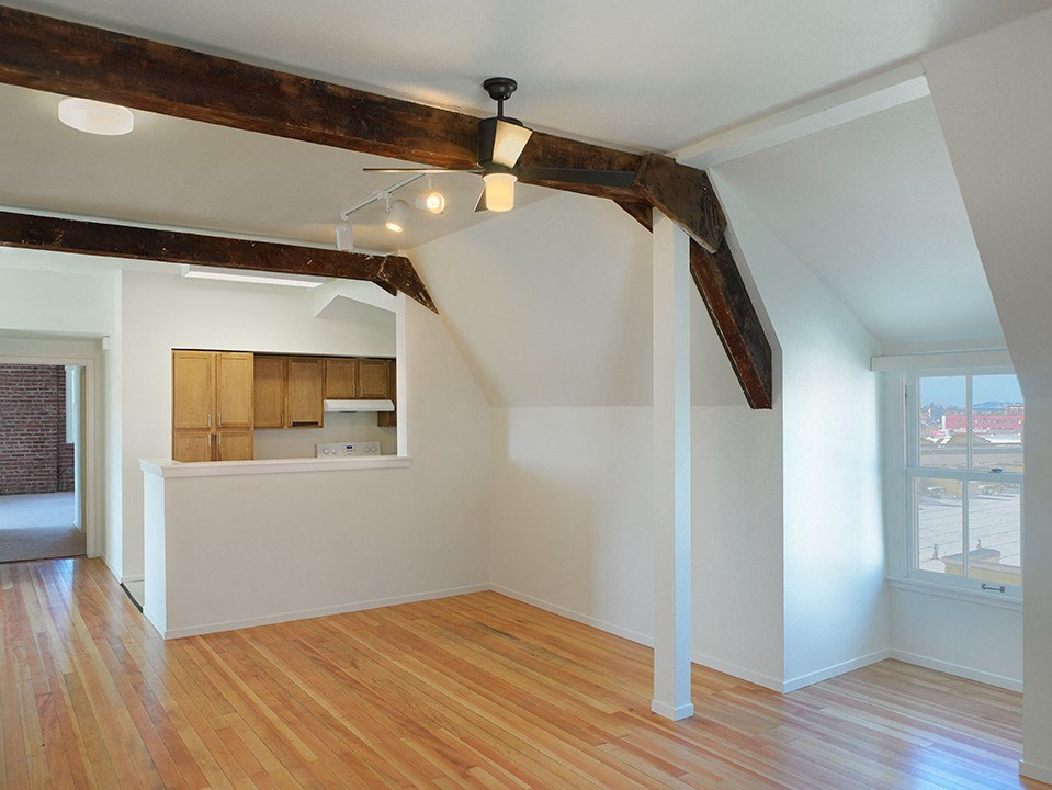 a living room with wood floors and a ceiling fan