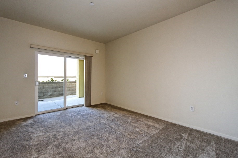 an empty living room with a door to a patio