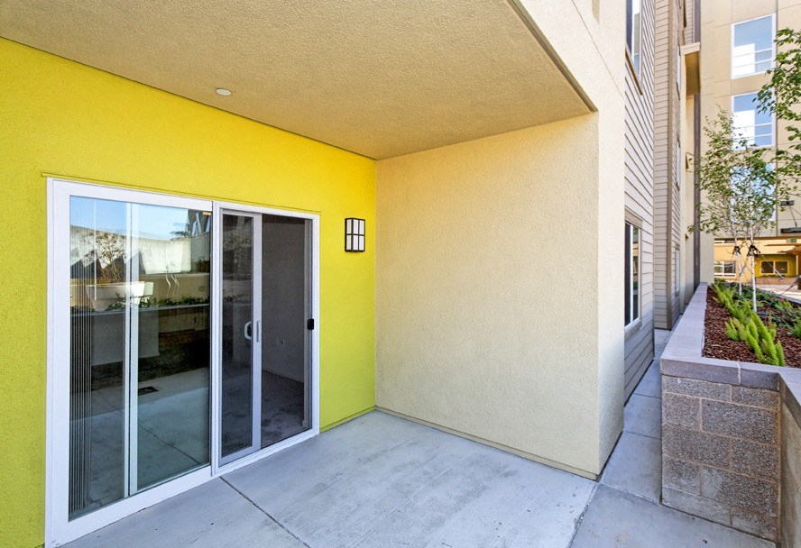 the entrance to a building with a yellow wall and glass doors