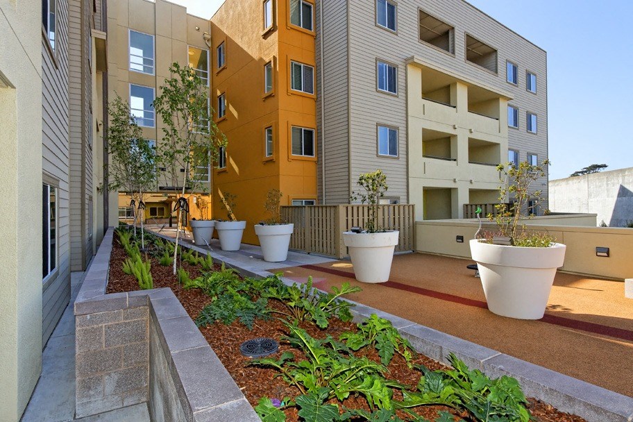 an apartment building with a garden in front of it