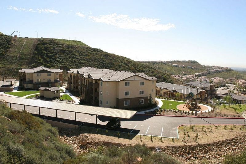 an aerial view of a building with a road and a mountain