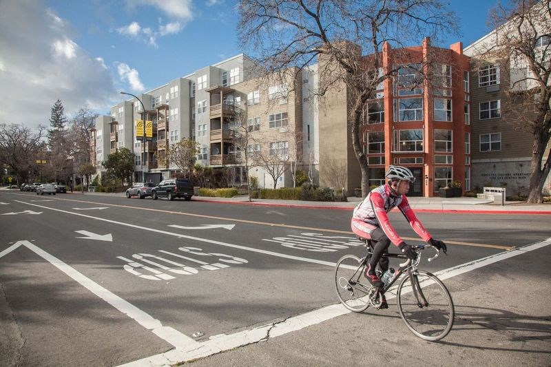 a man riding a bike on a city street