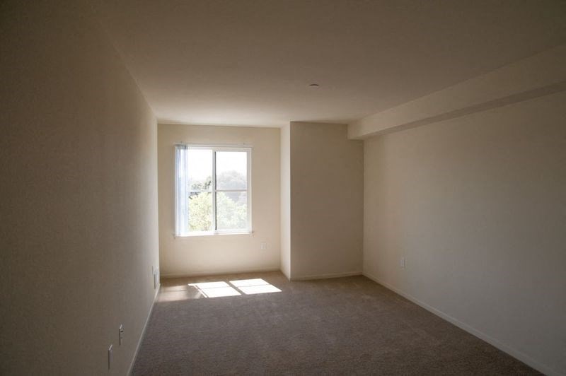an empty living room with a window in it