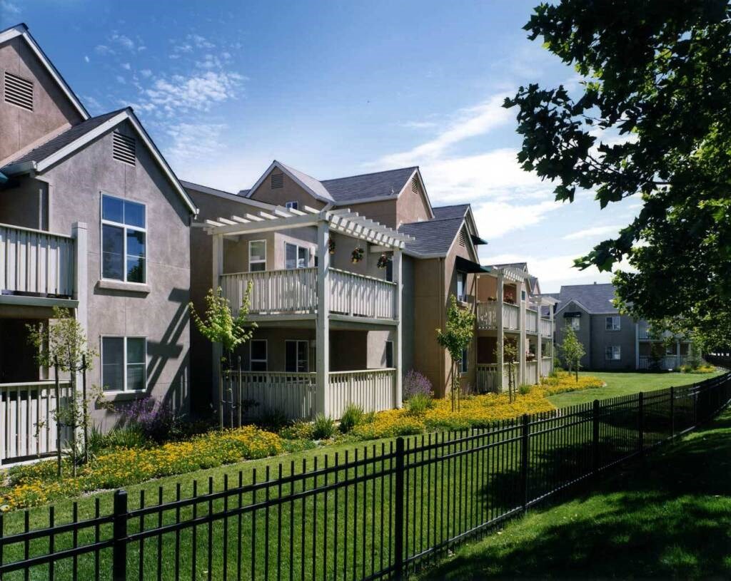 a row of houses with a yard and a fence
