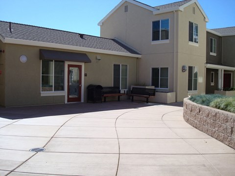 a driveway in front of a building with a bench on it