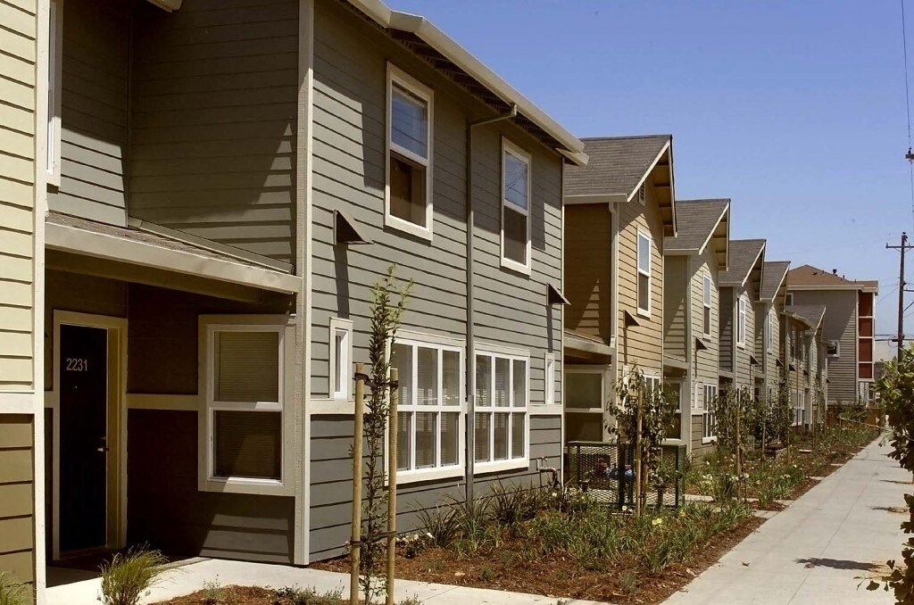a row of houses with a sidewalk in front of them