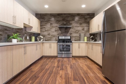 a kitchen with white cabinets and stainless steel appliances and wood floors
