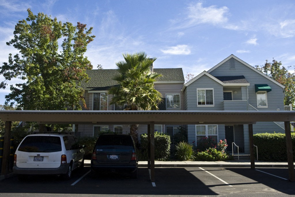 a blue house with two cars parked in a parking lot