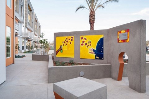 a fountain with three paintings on the side of a building