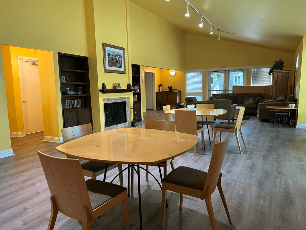 A living room with a fireplace and a dining table.