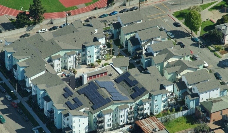 a group of houses with solar panels on the roofs
