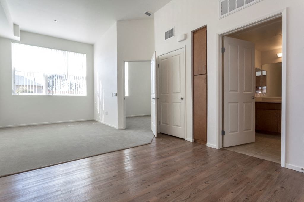 an empty living room with white walls and wood floors